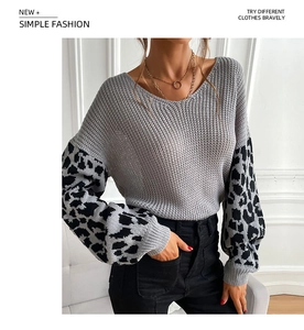 Detail of grey knit sweater showing V-neckline and leopard print patchwork sleeves