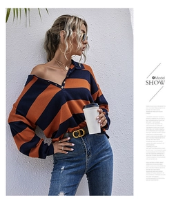 Détail d'un pull polo en maille rayé orange et bleu marine avec encolure à trois boutons