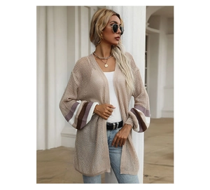 Detail view of hollow knit cardigan with striped lantern sleeves in a casual outdoor setting