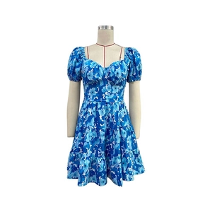 Détail de robe fleurie bleue avec décolleté en cœur, manches bouffantes et jupe à volants