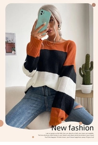 Detail of multi-color striped knit sweater with orange, black and white patterns