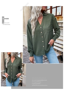 Detailed close-up of dark green V-neck shirt with breast pocket and wood-textured buttons