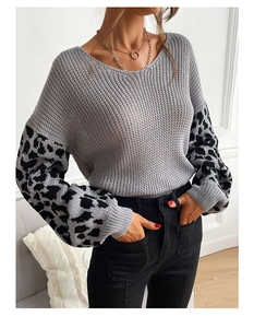 Detailed close-up of grey knit sweater featuring leopard print patchwork lantern sleeves