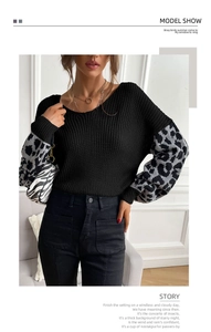 Detail shot of black knit sweater featuring stylish grey leopard print patchwork sleeves