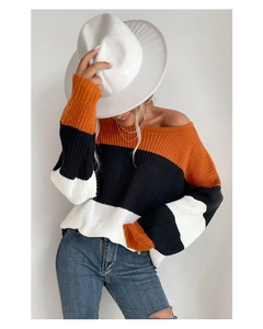 Detail of loose knit sweater showing orange, black and white stripes with textured weave