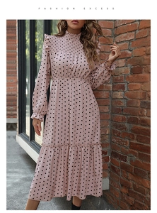 Detail of pink polka dot tiered dress featuring ruffled cuffs and elastic high neck