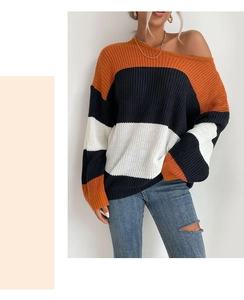Detail of loose knit sweater texture with orange, black and white striped pattern