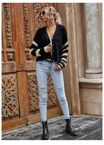 Detail of V-neck striped cardigan with gold buttons and contrast color knit sleeves