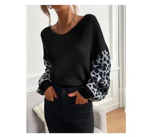 Detail of leopard print patchwork on loose-fitting black knit sweater with lantern sleeves
