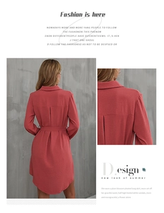 Detail of coral red shirt dress showing lapel collar and textured fabric with waist belt