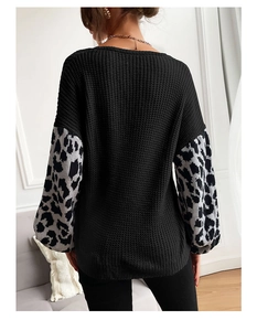 Detail view of oversized black knit sweater featuring leopard print sleeve patchwork