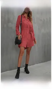 Detail of brick red long sleeve shirt dress featuring waist belt and front button pocket