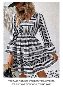 Close-up of V-neck and ruffled bell sleeves on a black and white geometric print dress