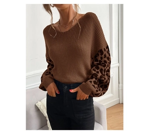 Close-up detail of leopard print patchwork on a loose brown knit sweater with round neck