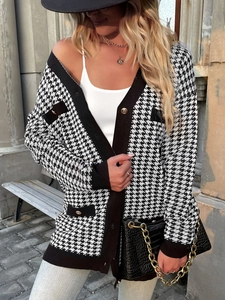Close-up of golden buttons on a houndstooth cardigan with black contrast trim