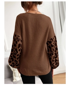 Detail view of the leopard print sleeve splicing and loose knit texture of the brown sweater