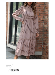 Detail showing the pink polka dot fabric and smocked high neck collar on the dress