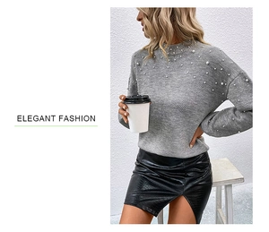 Detail of grey knit sweater with white pearl accents on neckline and drop shoulder design