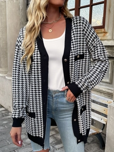 Detail of vintage houndstooth knit cardigan with gold buttons and black trim pockets