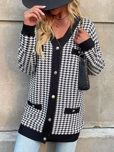 Detail of vintage houndstooth knit cardigan with golden buttons and black V-neck trim