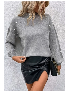 Detail of grey knit sweater featuring white pearls and elegant puffed sleeve texture