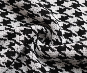 Macro shot of thick houndstooth knit fabric showing soft texture and premium weave detail