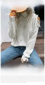 Detail of white off-shoulder knit sweater with high neck and distressed cutout texture