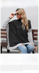 Close-up of black and white striped patchwork design on oversized high-neck knitted sweater