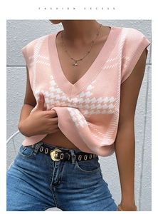 Detail of pink houndstooth knitted V-neck vest sweater with ribbed edges and soft texture