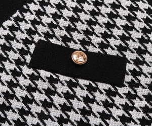 Macro shot of houndstooth knit texture with luxury gold metal button detail
