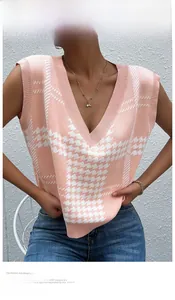 Close-up of pink and white houndstooth knit vest featuring V-neck and ribbed hem details