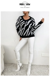 Macro detail of V-neck zebra print knit sweater with textured black and white patterns