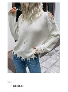 Detailed close-up of distressed white knit sweater featuring hollowed-out shoulder texture