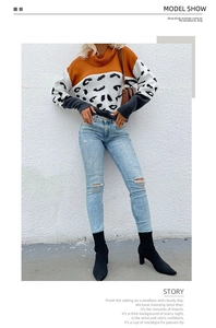 Detail of mock neck leopard print patchwork knit sweater with torn skinny jeans and boots