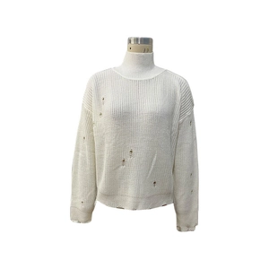 Detail of white turtleneck sweater showing distressed knit texture and ripped fringe design