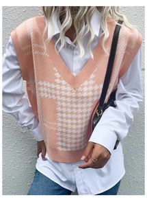 Detail of V-neck houndstooth knit vest in orange and white over a white shirt