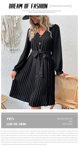 Close-up of V-neckline with buttons and pleated texture on black long sleeve dress