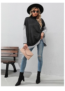 Close-up of loose knit sweater with striped contrast sleeves and turtleneck design