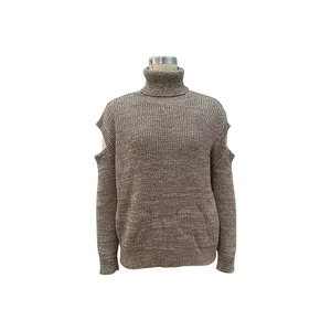 Detailed view of the turtleneck cutout shoulder design and ribbed cuffs on tan knit sweater