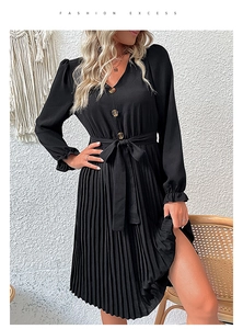 Detail of V-neck black pleated dress with amber buttons and elastic ruffled cuffs