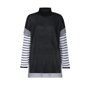 Detail of batwing sleeves with black and white stripes on high neck knitted sweater