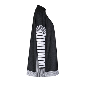 Detail of batwing sleeves and hem featuring black and white striped knit patterns