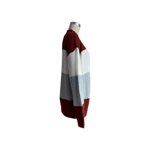 Detailed side view of a thick knit sweater with color-blocked burgundy and white stripes