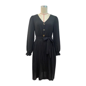 Detail of V-neckline with contrasting buttons and pleated hem on long sleeve black dress