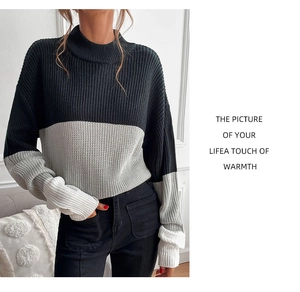 Detail of tricolor color-block knit sweater showing ribbed cuffs and thick texture