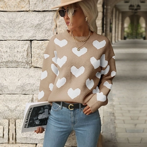 Detailed knit texture of khaki crewneck sweater with white heart pattern and ribbed cuffs