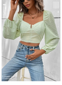 Detailansicht eines hellgrünen Crop-Tops mit Puffärmeln und strukturierter Kräuseloptik