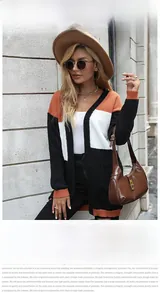 Detail of color-block knit cardigan in orange, white and black with a stylish V-neck design