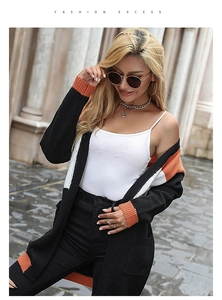 Detail of color-block long sleeve cardigan featuring black, orange, and white panels