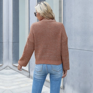 Women's oversized knit sweater in rust brown featuring a high neck and relaxed fit